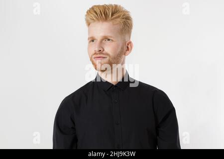 Nahaufnahme eines rothaarigen jungen Mannes mit rotem Bart in schwarzem stylischem Hemd auf grauem Hintergrund. Trendige Männer Haarschnitt und Haarpflege-Konzept. Gut Aussehend Stockfoto