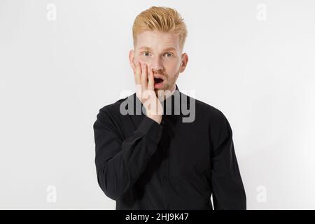 Aufgeregt überrascht Schock junger Mann auf grauem Hintergrund isoliert. Happy Redhead Kerl mit rotem Bart in schwarzem stylischem Hemd. Erfolgreich sein und Prüfungskonzept bestehen. Stockfoto
