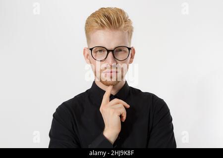 Junge Unternehmer generieren Geschäftsideen. Nahaufnahme von Thinking man in schwarzem Hemd und Brille isoliert, Kopierraum. Selbstverbesserung, ernsthafter männlicher f Stockfoto