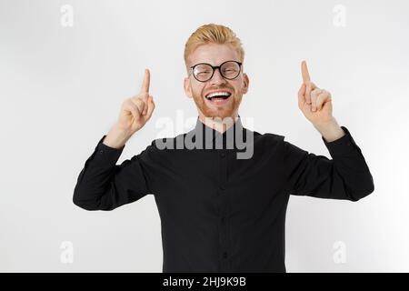 Happy stylish Kerl in schwarzem Hemd und Brille zeigt Kopie Raum. Erfolgreicher junger Mann Unternehmerkonzept. Rothaariger Mann mit rotem Bart. Starten, y Stockfoto