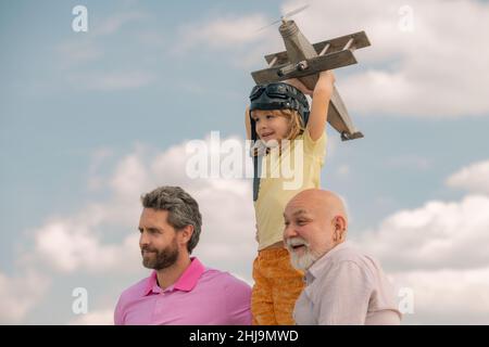 Großvater Vater und Sohn spielen mit Spielzeug Flugzeug im Freien am Himmel. Frohe Familie. Drei-Mann-Generation. Frohe Kindheit. Der Familienmensch hat verschiedene Altersgruppen Stockfoto