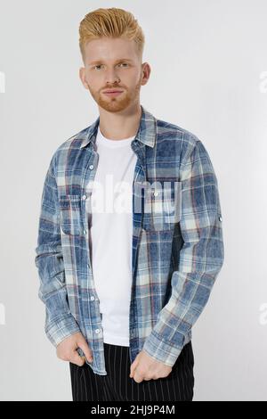 Junger rothaariger Mann mit rotem Bart in leerem Sommer-T-Shirt, kariertes Hemd isoliert auf weißem Hintergrund. Unrasiert selbstbewusst ernster männlicher Unternehmer. Cop Stockfoto