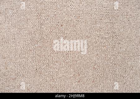Beige handgemachte Wollstrick, Wollstrick für handwerklichen Hintergrund oder Hintergrund. Beige gestrickter Hintergrund. Draufsicht Stockfoto