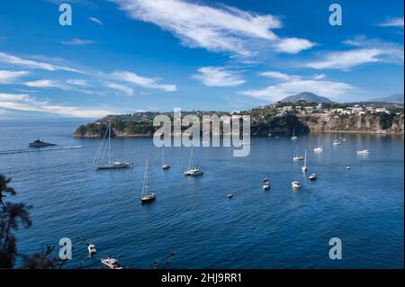 Panoramablick auf die schöne Procida in sonnigen Sommertag. Bunte Häuser, Fischerboote und Yachten in Marina Corricella, Procida, Italien, Neapel Stockfoto