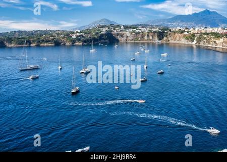 Panoramablick auf die schöne Procida in sonnigen Sommertag. Bunte Häuser, Fischerboote und Yachten in Marina Corricella, Procida, Italien, Neapel Stockfoto