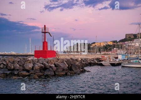 Ein wunderschöner Sonnenuntergang, der sich auf die bunten Häuser des Hafens von procida spiegelt Stockfoto