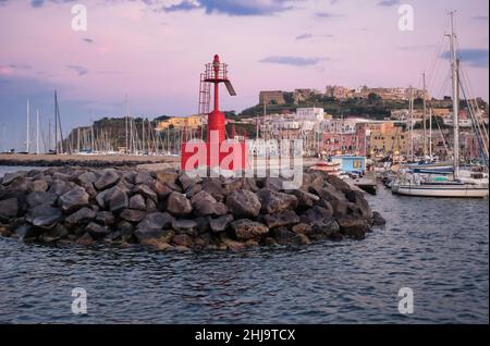 Ein wunderschöner Sonnenuntergang, der sich auf die bunten Häuser des Hafens von procida spiegelt Stockfoto