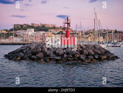 Ein wunderschöner Sonnenuntergang, der sich auf die bunten Häuser des Hafens von procida spiegelt Stockfoto
