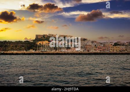 Ein wunderschöner Sonnenuntergang, der sich auf die bunten Häuser des Hafens von procida spiegelt Stockfoto