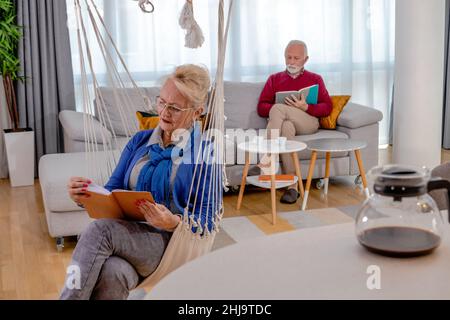 Ein reizendes Ehepaar, das sich zu Hause ausruhte und las. Stockfoto