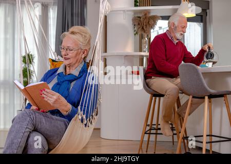 Ein reizendes Ehepaar, das sich zu Hause ausruhte und las. Stockfoto