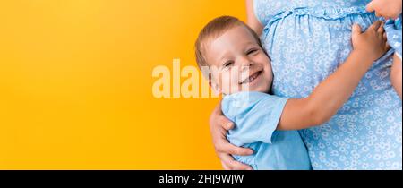 Mutterschaft, Weiblichkeit, Liebe, Kindheit, heißer Sommer - croped Banner schwanger unkenntlich Frau blaues Kleid kleine Vorschule Junge Sohn Geschwister Umarmung Mutter Stockfoto