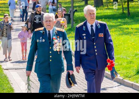 Zur Feier des Sieges in Minsk (Weißrussland) gehen die Veteranen der sowjetischen Armee, des Panzeroberstleutnants und des Fliegerleutnants in der vollen Uniform. Stockfoto