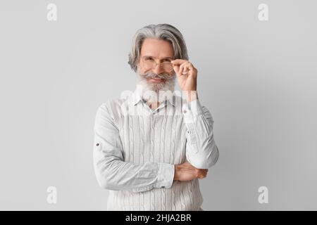 Älterer Mann in Brillen auf hellem Hintergrund Stockfoto
