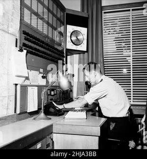 Aylesbury Police Headquarters, Buckinghamshire, im Kontrollraum des Polizeihauptquartiers während die Jagd nach der Großen Mail Gang am Montag, den 12th. August 1963, fortgesetzt wird. Unser Bild Zeigt ... Der Polizist am Kontrollpult des Radios gibt Informationen an die Beamten auf dem Feld weiter. Der große Eisenbahnraub von 1963 war der Raub von £2,6 Millionen von einem Royal Mail-Zug, der von Glasgow nach London auf der West Coast Main Line in den frühen Morgenstunden des 8th. August 1963 an der Bridego Railway Bridge, Ledburn, in der Nähe von Mentmore in Buckinghamshire, England, fuhr. Stockfoto