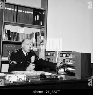 Aylesbury Police Headquarters, Buckinghamshire, im Kontrollraum des Polizeihauptquartiers während die Jagd nach der Großen Mail Gang am Montag, den 12th. August 1963, fortgesetzt wird. Unser Bild zeigt ... Polizeigeant an seinem Schreibtisch im Kontrollraum. Der große Eisenbahnraub von 1963 war der Raub von £2,6 Millionen von einem Royal Mail-Zug, der von Glasgow nach London auf der West Coast Main Line in den frühen Morgenstunden des 8th. August 1963 an der Bridego Railway Bridge, Ledburn, in der Nähe von Mentmore in Buckinghamshire, England, fuhr. Stockfoto