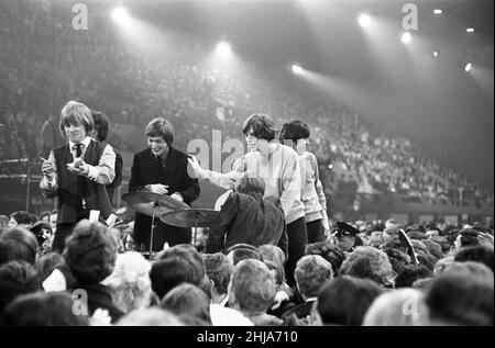 Am 20. November 1964 fand der von der London University organisierte Glad Rag Ball im Empire Pool, Wembley, London, statt. Die Show begann um 9 Uhr und endete um 7 Uhr mit 7.000 Menschen, die in allen möglichen Kleidungsstücken aufzeigten. Die Show wurde von Jimmy Savile moderiert und zeigte die Rolling Stones, Animals, Long John Baldry, Susan Maughan, Lorne Lesley, Ginger Johnson & seine African Drummers und Humphrey Lyttelton. Die Rolling Stones auf der Bühne. Stockfoto