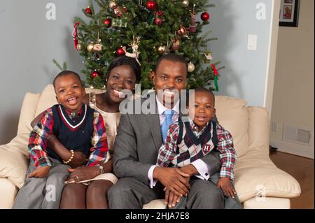 Familienportrait zu Hause Weihnachtszeit Weihnachtseltern im Alter von 30s Jahren mit Söhnen im Alter von 2 und 4 Jahren Stockfoto