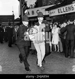 Eine große Menge versammelte sich in der Ridley Road, E8, um gegen den ehemaligen faschistischen Führer Sir Oswald Mosley und Mitglieder seiner antisemitischen Blackshirt-Gruppe zu demonstrieren, die eine Kundgebung im Londoner East End geplant hatten. Mosley und seine Gruppe wurden angegriffen und zu Boden geschlagen, sobald sein Treffen in der Ridley Road, Dalston, eröffnet wurde. Die Polizei schloss das Treffen innerhalb der ersten drei Minuten ab und verhaftete 54 Personen, darunter Sir Oswalds Sohn Max. Die Polizei verhaftete einen der wütenden Demonstranten. 31st. Juli 1962. Stockfoto