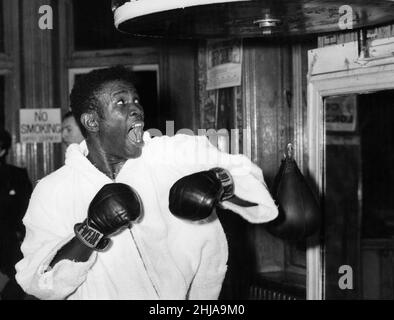 Welterweight-Weltmeister Emile Griffith aus den USA, der am 1st. Dezember in Wembley für seinen bevorstehenden Kampf gegen Dave Charnley trainiert und den Speed Ball so hart geschlagen hat, dass er ihn von seinem Fundament weggeschlagen hat. Aufgenommen am 23rd. November 1964. Stockfoto