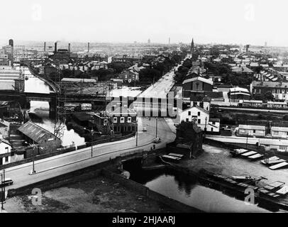 Blick über Bootle, Liverpool, von der Spitze eines sechzehn-stöckigen Wohnblocks, der in die Sanierung der Church Street von 199 Häusern an der Coffee House Bridge integriert ist. Es zeigt die Szene, die auf die Meron Road mit der Christ Church oben und dem Leeds to Liverpool Canal im Vordergrund schaut. 22nd. Juni 1964. Stockfoto