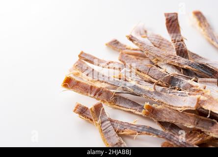 Getrockneter Tintenfisch auf weißem Hintergrund. Surume ist ein japanischer Snack. Stockfoto