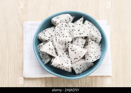 Eine Schale mit frischen Drachenfrüchten auf Holzgrund. Frühstück Obst am Morgen. Stockfoto