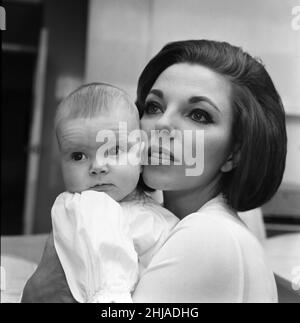 Joan Collins im Bild mit ihrer vier Monate alten Tochter Tara Newley. Sie sind nach London gekommen, um die Familie zu sehen. Hier sind sie heute, nachdem Mutter in den Filmstudios war und Baby Tara nach ihrem Schlaf aufwachte. 20th. Februar 1964. Stockfoto