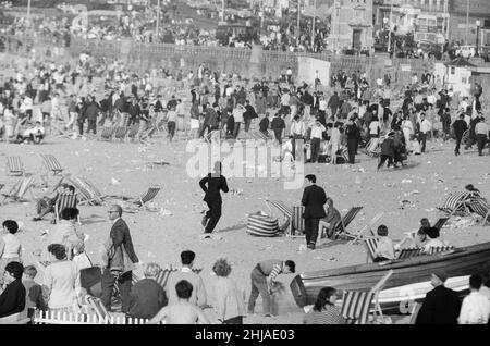 Mods gegen Rockers. Bild zeigt die Szene in Margate, North East Kent im Mai 1964. Die Polizei läuft rüber zu den Mods und Rockers, um zu versuchen, die Unruhestifter zu beruhigen. Bild aufgenommen am 17th. Mai 1964 Stockfoto