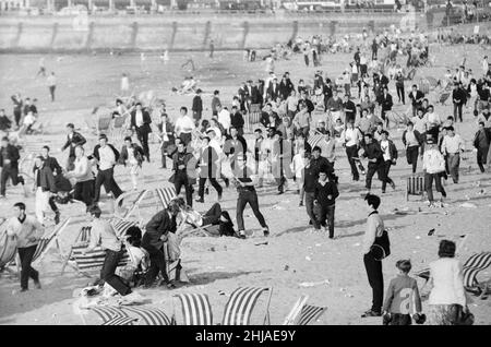 Mods gegen Rockers. Bild zeigt die Szene in Margate, North East Kent im Mai 1964. Mods laufen über den Strand und stören die Urlauber, während sie gehen. Bild aufgenommen am 17th. Mai 1964 Stockfoto