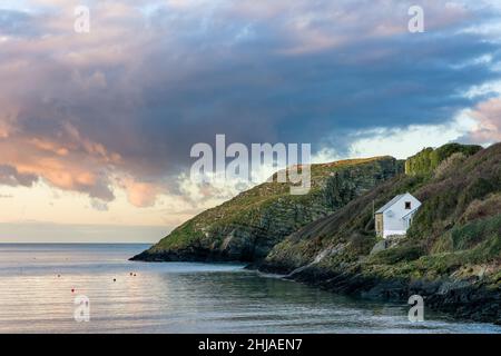 Eine kleine Bucht mit Sonnenuntergangshimmel in Abercastle an der walisischen Küste Stockfoto