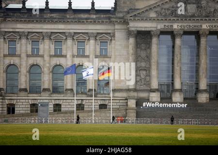 Berlin, Deutschland. 27th Januar 2022. Der Deutsche Bundestag beteiligt sich in diesem Jahr an der Kampagne „#WeRemember“ anlässlich des Internationalen Holocaust-Gedenktages am Donnerstag, 27. Januar 2022. Das Foto zeigt das Reichstagsgebäude mit Flaggen am Halbmast und weißen Buchstaben WeRemember. (Bild: © Simone Kuhlmey/Pacific Press via ZUMA Press Wire) Stockfoto