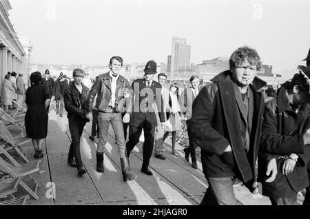 Mods gegen Rockers. Bild zeigt die Szene in Margate, North East Kent im Mai 1964. Ein Jugendlicher wird von der Polizei in Handschellen gelegt und weggebracht. Foto vom 17th. Mai 1964 Stockfoto