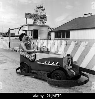 Russell Smith von Southport zeigt, wie fit man bei 80 sein kann. Herr Smith, ein pensionierter Wirtschaftsingenieur, behauptet, dass das Geheimnis, jung zu bleiben, 3,5 bis 5 Minuten Training pro Tag sind. Er ist in einem Autoscooter mit der Urlaubsfahrerin Eveline Uren aus Newcastle abgebildet. 30th. Juni 1962. Stockfoto