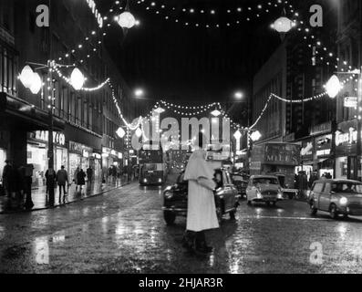 Ein Blick auf die Lichter in der Lord Street mit Blick auf den Derby Square, aufgenommen, während die Menschen durch starken Regen für ihre Busse nach Hause schimpfen. Liverpool, Merseyside. 22nd. November 1962. Stockfoto