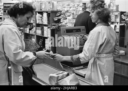 Shopper, Fine Fare Supermarket, Wilton, London, 29th. Oktober 1963. Sammeln Sie Green Shield Briefmarken an der Kasse, nachdem Sie für Waren bezahlt haben. Green Shield Stamps ist ein britisches Verkaufsförderungsprogramm, das Käufer mit Briefmarken belohnt, die eingelöst werden können und zum Kauf von Geschenken aus einem Katalog oder einem angeschlossenen Einzelhändler verwendet werden. Stockfoto