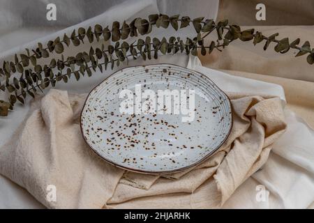 Keramikplatten mit getrockneten Blüten auf Calico. Keramik Geschirr, schöne Anordnung. Stockfoto