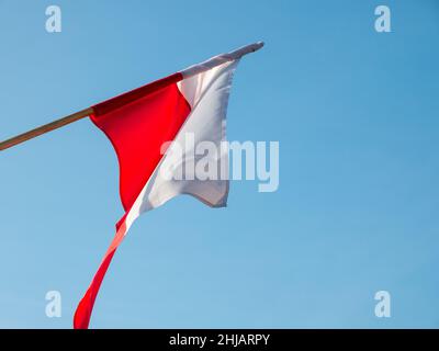 Polnische rot-weiße Flagge auf blauem Himmel Hintergrund Stockfoto