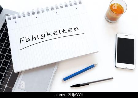 Faehigkeiten - deutsch Wort für Fähigkeiten oder Fähigkeiten - handgeschriebener Text in einem Notizbuch auf einem Schreibtisch - 3D Darstellung. Stockfoto