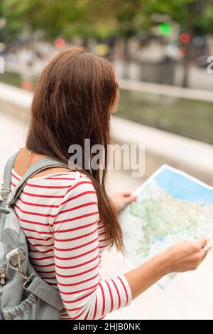 Anonyme Frau mit Rucksack und Karte in der Stadt Stockfoto