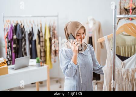 muslimische Geschäftsfrau als Modedesignerin telefonisch anrufen Stockfoto