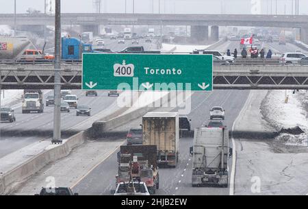 Ontario, Kanada. 27th Januar 2022. Am 27. Januar versammeln sich auf einer Brücke über den Highway 400 Menschen zur Unterstützung von Lastwagenfahrern, die sich auf dem Weg nach Ottawa zum Protest des „Freiheitskonvois“ in Vaughan, Ontario, Kanada, befinden. 2022. Der „Freiheitskonvoi“ wurde durch Empörung über ein kürzlich erzwungene Impfmandat gegen kanadische und US-amerikanische Grenzgänger ausgelöst. Quelle: Zou Zheng/Xinhua/Alamy Live News Stockfoto