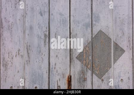 Nahaufnahme der alten und rauen Oberfläche der lackierten grauen Holzwand mit einem dunklen Rechteck gestempelt. Stockfoto