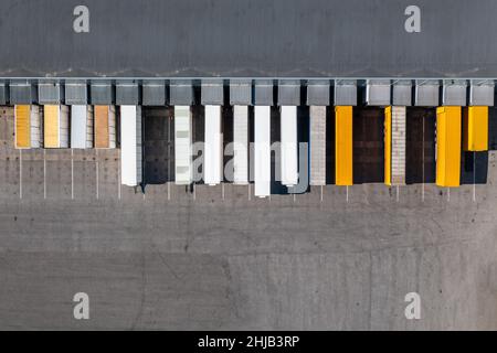 LKW-Anhänger im Logistikterminal. Transport- und Frachtzustellungskonzept. Luftaufnahme von oben nach unten. Stockfoto