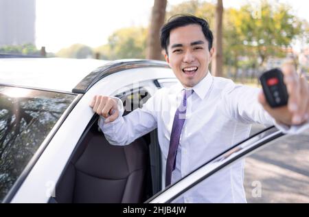 Glücklicher Geschäftsmann, der die Autoschlüssel zeigt Stockfoto