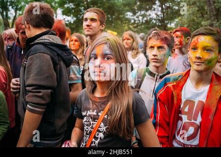 Junge Leute, die Spaß haben und zusammen beim Holi-Farbfestival im Park in Gomel, Weißrussland tanzen Stockfoto