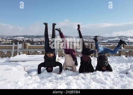 Junge Israelis stehen auf dem Kopf, während sie den Schneefall am 27. Januar 2022 in Jerusalem, Israel, genießen. Jerusalem wurde über Nacht von Schnee bedeckt, der 10 bis 20 Zentimeter (vier bis acht Zoll) erreichte. Stockfoto