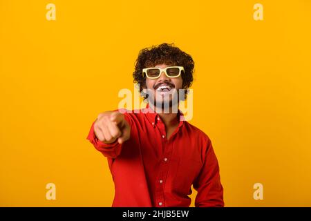 Ihr seid etwas Besonderes. Positiver glücklicher Mann, der mit den Fingern auf die Kamera zeigt und mit toothy Lächeln schaut, glaubt an dich, Motivation. Innenaufnahme des Studios isoliert auf orangefarbenem Hintergrund Stockfoto