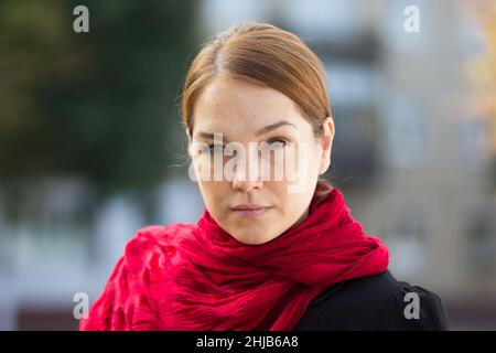 Porträt einer ernst zu nehmenden kaukasischen Frau mittleren Alters, die die Kamera im Freien betrachtet Stockfoto