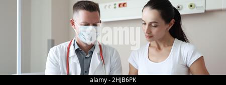 Der Arzt führt die ärztliche Untersuchung der Patientin in der Klinik durch Stockfoto